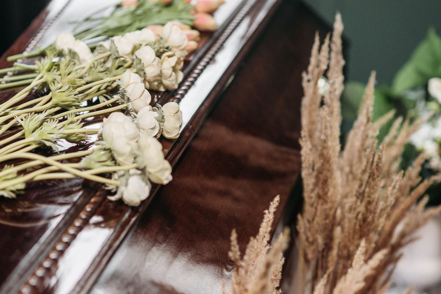 Flores blancas sobre un ataúd de madera