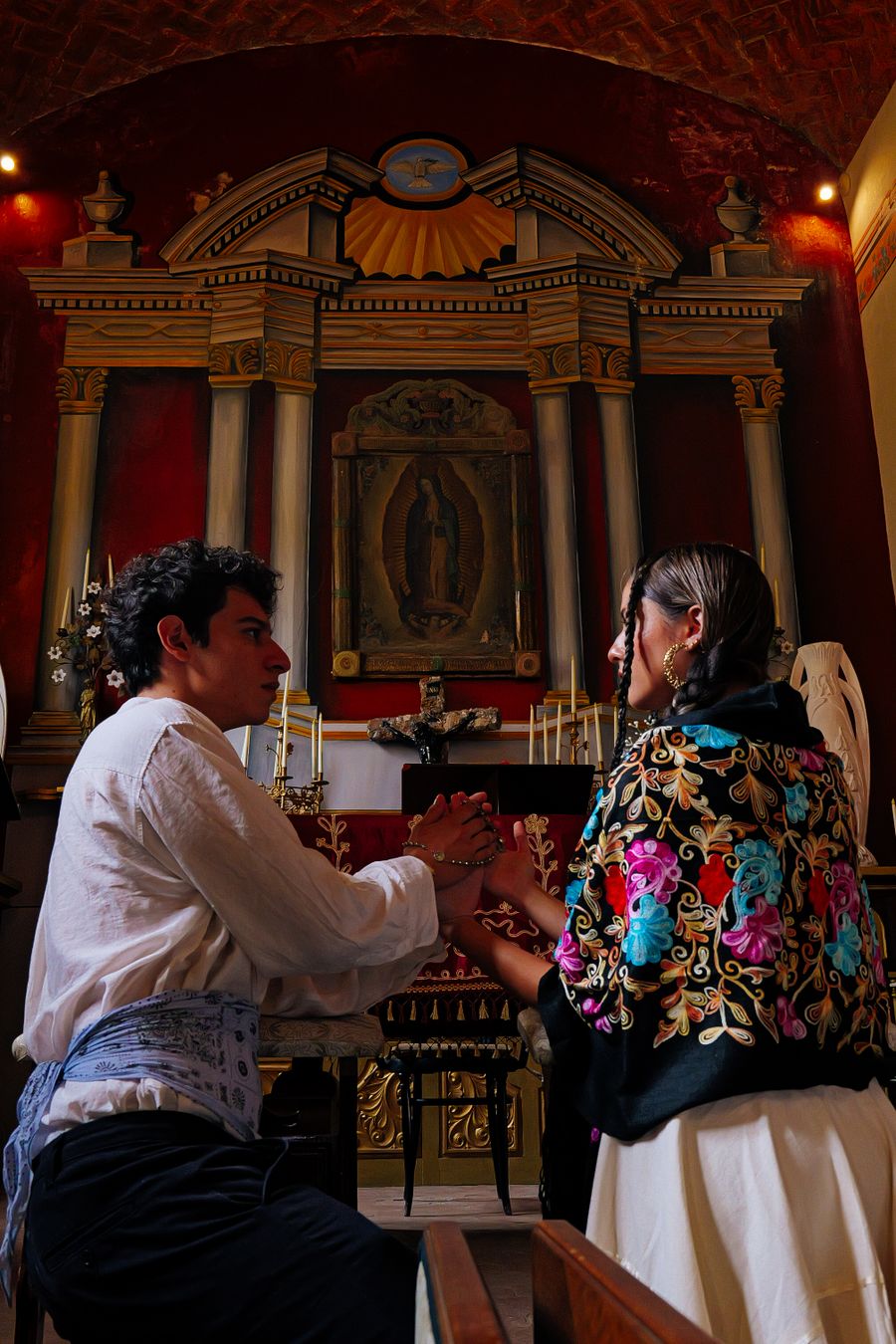 Pareja rezando ante la Virgen de Guadalupe